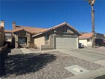 Exterior featuring a tile roof, low maintenance landscaping, and attached garage at 2266 Carved Canyon Ln, Laughlin, NV 89029