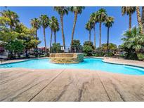 Relaxing community pool surrounded by mature palm trees and comfortable lounge chairs at 4730 E Craig Rd # 1093, Las Vegas, NV 89115