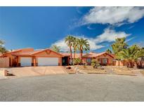 Spacious home with a three-car garage, desert landscaping, and mature palm trees at 4775 N Grand Canyon Dr, Las Vegas, NV 89129
