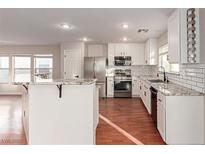 Bright kitchen with white cabinets, granite countertops, stainless steel appliances, and tile backsplash at 5317 Welch Valley Ave, Las Vegas, NV 89131