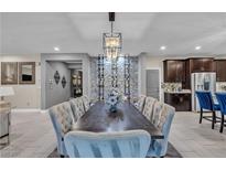 Elegant dining room with a large table, stylish chairs, a wine rack, and a modern chandelier at 7333 Night Sky St, North Las Vegas, NV 89084