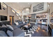 Bright living room features a fireplace, dark wood floors, and flows into the kitchen at 7520 Jacaranda Bay St, Las Vegas, NV 89139
