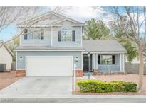 Charming two-story home with light blue siding, two-car garage, and cozy front porch at 7620 Whispering River St, Las Vegas, NV 89131