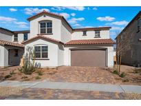 Beautiful two-story home featuring a red tile roof, stucco exterior, and a two car garage with brick paved driveway at 184 May Park Ave, Henderson, NV 89011