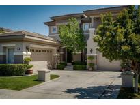Elegant two-story home with a well-manicured lawn, mature trees, and a spacious three-car garage at 504 Pinnacle Heights Ln, Las Vegas, NV 89144