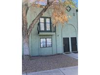Two-story townhome showcasing dual entry doors and a quaint balcony, all set against a backdrop of low-maintenance landscaping at 7095 Burcot Ave # F83, Las Vegas, NV 89156