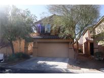 Charming two-story home featuring a tan exterior, well-manicured landscaping, and a convenient two-car garage at 7403 Benlomond Ave, Las Vegas, NV 89179