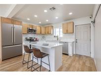 Bright kitchen boasts stainless appliances, light wood cabinets, and a center island with bar seating at 1209 S 17Th St, Las Vegas, NV 89104
