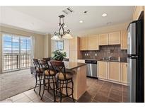 Well-lit kitchen features tile flooring, granite countertops, stainless steel appliances, and breakfast bar seating at 2405 W Serene Ave # 631, Las Vegas, NV 89123