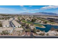 Scenic aerial view of a golf course community with water feature and mountain backdrop on a sunny day at 4820 Grey Wolf Ln # 101, Las Vegas, NV 89149