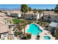 Overhead view of a community pool with palm trees and manicured landscaping in a residential complex at 4820 Grey Wolf Ln # 101, Las Vegas, NV 89149