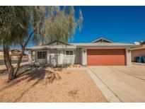 Home with a large, two-car garage door and low-maintenance desert landscaping in the front yard at 6284 Pinewood Ave, Las Vegas, NV 89103