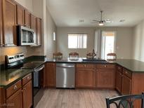 A kitchen featuring wood cabinetry, stainless steel appliances, and a functional layout with a sink and counter space at 6420 Emerson St, Pahrump, NV 89048