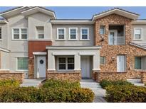 Beautiful townhome featuring a stone facade, neutral stucco, manicured shrubs, and a cozy front entry at 7544 Nicklin St, Las Vegas, NV 89143