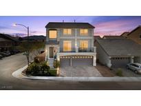 Elegant two-story home featuring a three-car garage and a charming front yard with lush landscaping at 9783 Hawk Crest St, Las Vegas, NV 89141