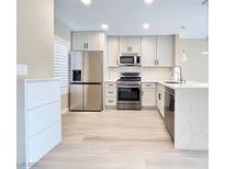 Modern kitchen with stainless steel appliances, white cabinets, and a center island at 8070 W Russell Rd # 2070, Las Vegas, NV 89113