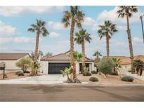 Charming single-story home features desert landscaping, palm trees, and a two-car garage at 1110 Broken Hills Dr, Henderson, NV 89011