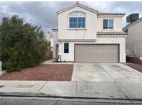 Two-story home featuring a two-car garage, stucco exterior, and desert landscaping at 1844 Navajo Lake Way, Las Vegas, NV 89128