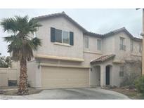 Charming two-story home featuring a two-car garage, neutral stucco, and a mature palm tree in the front yard at 5861 Old English Ct, Las Vegas, NV 89139