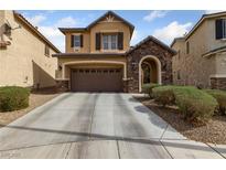 Charming two-story home features a stone-accented entrance, attached garage, and a well-maintained front yard at 6030 Hidden Summit St, North Las Vegas, NV 89031