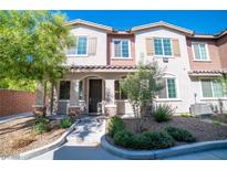 Charming townhome with a beautifully landscaped front yard and inviting covered entry with decorative stone accents at 8487 Insignia Ave # 105, Las Vegas, NV 89178
