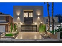 Contemporary home featuring a modern design with a glass garage door and minimalist landscaping at 2819 Queens Courtyard Dr, Las Vegas, NV 89109