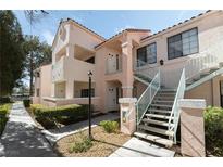 Inviting condo with exterior stairs, landscaped grounds, and a light pink facade at 4861 S Torrey Pines Dr # 106, Las Vegas, NV 89103