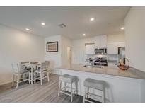 Bright kitchen featuring a breakfast bar, stainless steel appliances, and an adjacent dining area at 542 Foothill Cove Ln, Henderson, NV 89002