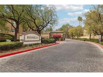 Entrance to Redhills community featuring lush landscaping and controlled access at 8728 Red Rio Dr # 201, Las Vegas, NV 89128