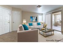 Bright living room features neutral walls, tile floors and a sliding glass door to the outdoor patio at 1560 Jamielinn Ln # 101, Las Vegas, NV 89110