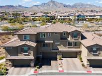 Inviting townhouse showcasing a tile roof, multiple garages, and a picturesque mountain view in the background at 185 Lomita Heights Dr, Las Vegas, NV 89138
