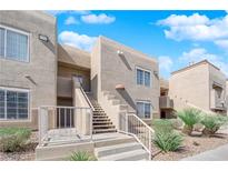 Inviting condo building exterior with well-maintained landscaping and visible stairway access at 1909 Mountain Hills Ct # 103, Las Vegas, NV 89128