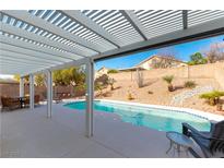 Inviting backyard pool with shaded patio and desert landscaping at 3215 Stratford Hall Ct, Las Vegas, NV 89135