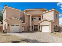 Elegant two-story home featuring a brick driveway, three-car garage, and a landscaped front yard at 3789 Gershon Ct, Las Vegas, NV 89121