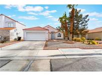 Charming single-story home with a two-car garage, red tile roof, and manicured landscaping at 3812 Blue Dawn Dr, North Las Vegas, NV 89032