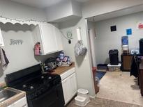 A functional kitchen featuring white cabinets and black appliances for cooking needs at 3934 Torsby Pl, Las Vegas, NV 89119