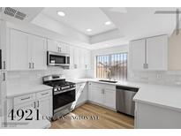 Modern kitchen featuring stainless steel appliances, white cabinets, and beautiful quartz countertops at 4921 E Washington Ave, Las Vegas, NV 89110