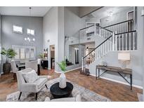 Inviting living room with high ceilings, neutral tones, modern chandelier, and staircase access at 6709 Rancho Santa Fe Dr, Las Vegas, NV 89130