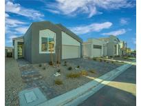 Contemporary home featuring neutral stucco, a two-car garage, and low maintenance desert landscaping at 10009 Locking Biner Ave, Las Vegas, NV 89166