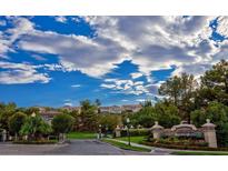 Presidio community entrance with lush landscaping and beautiful blue sky and cloud background at 1353 Volturno Way, Henderson, NV 89052