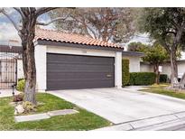 Exterior of home featuring a concrete driveway leading to a two car garage and tiled roof at 3440 Pino Cir, Las Vegas, NV 89121