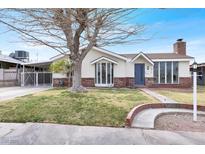 Charming home featuring large windows and a well-maintained front yard with mature trees at 612 Burton St, Henderson, NV 89015