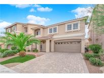 Two story home with a brick driveway, two-car garage and manicured landscaping at 6435 Parrot Ridge Ct, Las Vegas, NV 89139