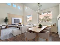 Modern living room featuring a large sectional sofa, dining table, and a decorative media center at 800 Fetter Ct, Henderson, NV 89052