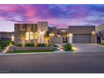Contemporary home boasts desert landscaping, stone accents, and a paved driveway under a colorful sunset sky at 819 Bolide St, Las Vegas, NV 89138