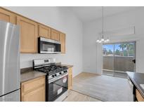 Bright kitchen features stainless steel appliances, gas range, and sliding door to patio at 8805 Jeffreys St # 2082, Las Vegas, NV 89123