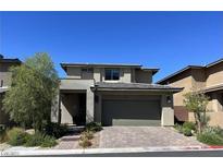 Two-story home features a brick driveway, neutral stucco, a 2-car garage, and desert landscaping at , Las Vegas, NV 89148