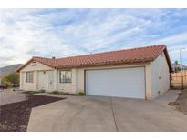 Cozy single-story home featuring a tile roof, neutral stucco and an attached two-car garage at 1892 Maricopa Dr, Laughlin, NV 89029