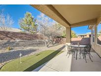 Inviting covered patio with a mini putting green, perfect for outdoor dining and relaxation at 2384 Yellow Bird Ct, North Las Vegas, NV 89084
