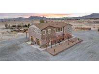 Stunning multi-story home with stone accents, desert landscaping, and mountain views at sunset at 2590 Luke St, Pahrump, NV 89060